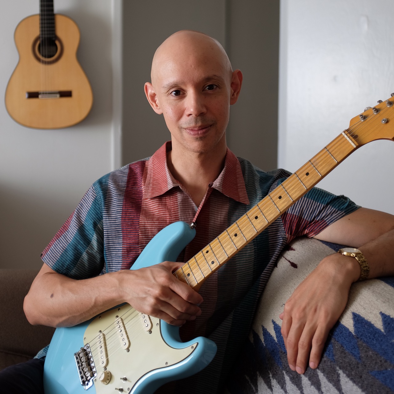 A photo of Philip Graulty holding an electric guitar.
