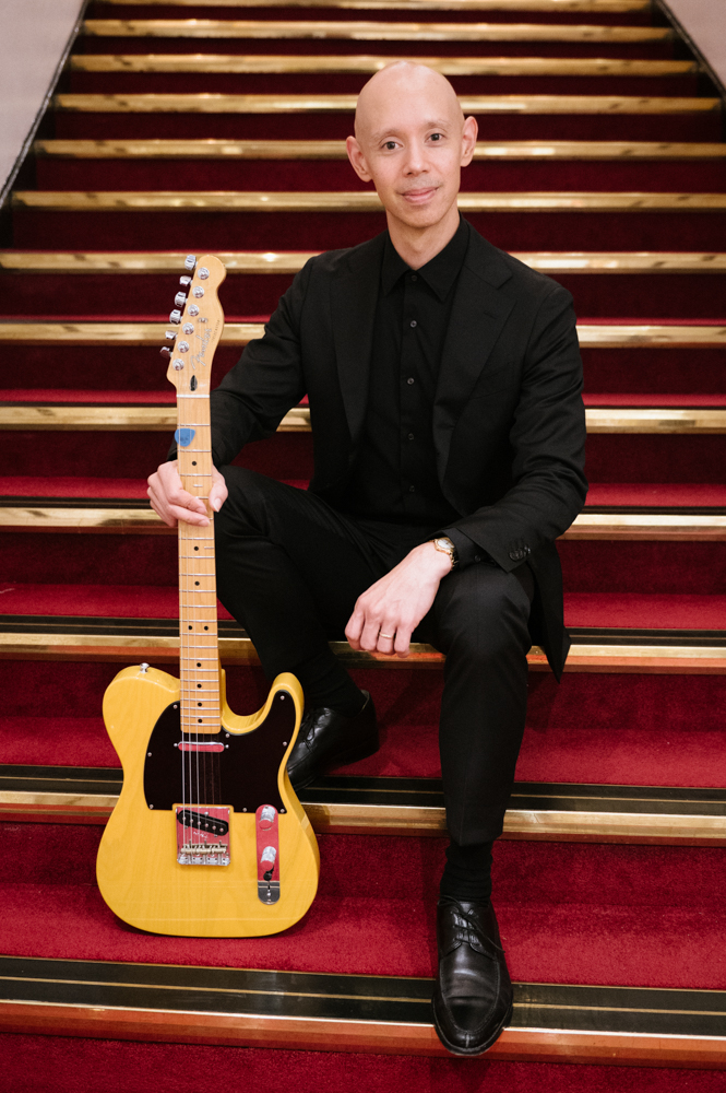 A photo of Philip Graulty holding an electric guitar.